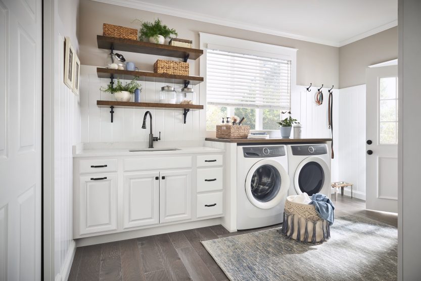 a laundry room remodel with cabinetry and floating shelves in white