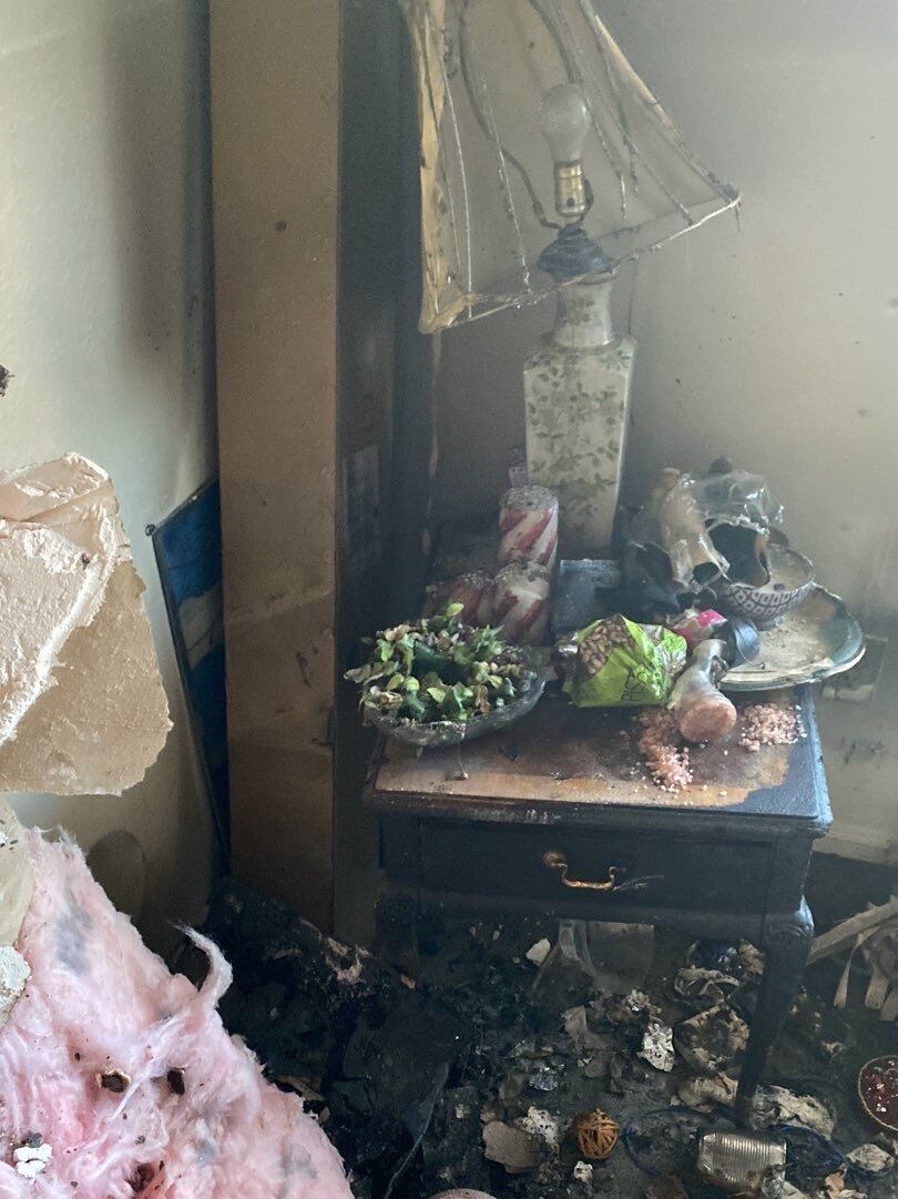 fire damaged bedroom contents covered in soot and fallen insulation